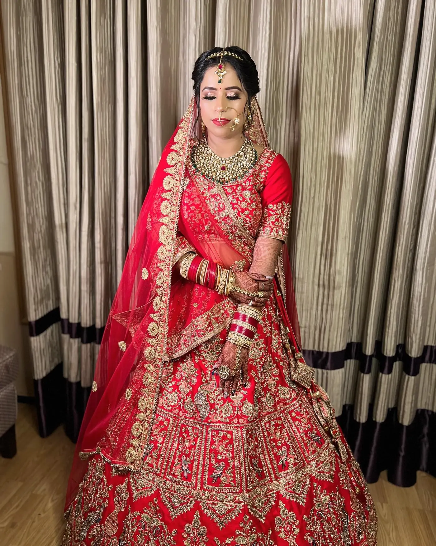Red Lehenga, Standing Portrait. Bridal makeup by Madhu Gupta at MG Makeovers, Gurugram